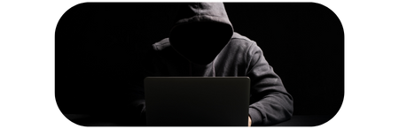 Zakapturzona postać przed laptopem